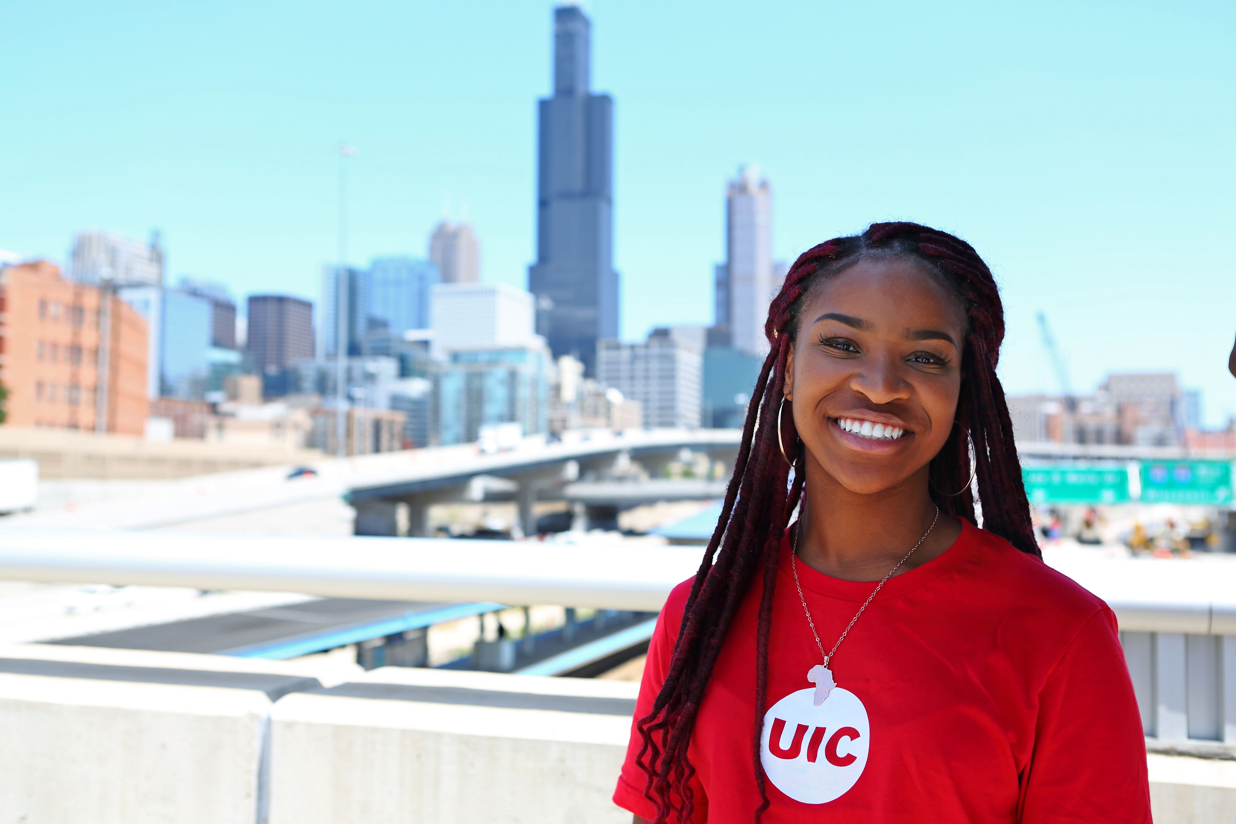 Woman in a red shirt smiling in front of the city of chicago